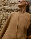 Close-up model wearing the Coyuchi Top, highlighting the natural earthy tone of 100% native organic cotton. 