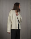 Side view of the Desert jacket highlighting the batwing sleeves and the eclean, minimalistic V-neck collar. 