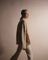 Side view of the DESI jacket, showcasing how the fringes accentuate the architectural lines of the sleeves and shoulders.