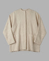 Flat lay of the Kala jacket, displaying the practical front pockets and the invisible nacra button detailing. 