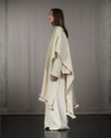 Profile of the Nube poncho, showing the structured silhouette and the raw texture of desert wool. 