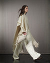 Side view of model in motion wearing Nube poncho, showcasing the natural drape of hand-spun Desi wool. 