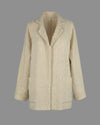 Flat lay front view of the Sofia jacket, displaying its minimalist construction and natural cream color. 